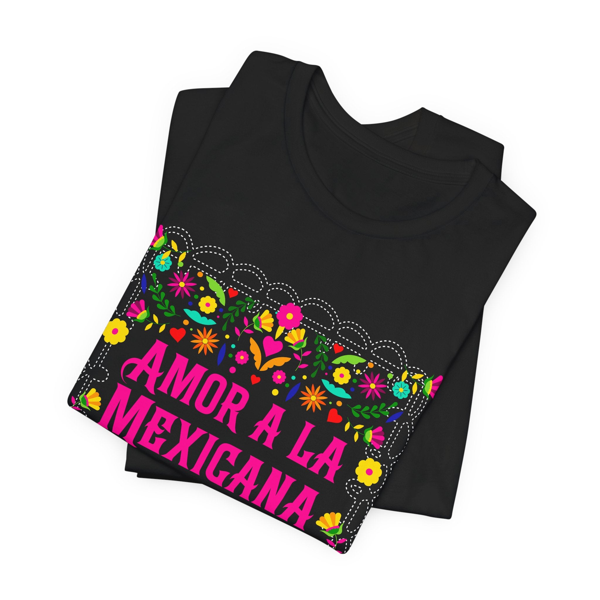 Black t-shirt with pink "Amor a la Mexicana" text surrounded by a colorful floral frame inspired by Mexican folk art.