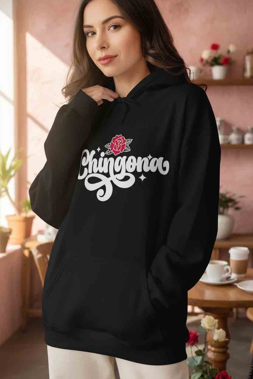 Latina woman wearing black Chingona hoodie - bold white typography red rose closeup
