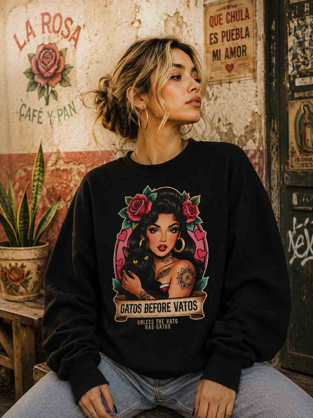Chicana woman with cat wearing Gatos Before Vatos sweatshirt, urban fashion, Latina pride.