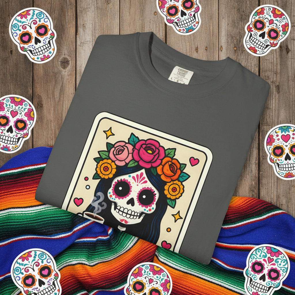 Vintage lotería card design on a t-shirt featuring a sugar skull calavera holding a coffee cup with the text La Chismosa.