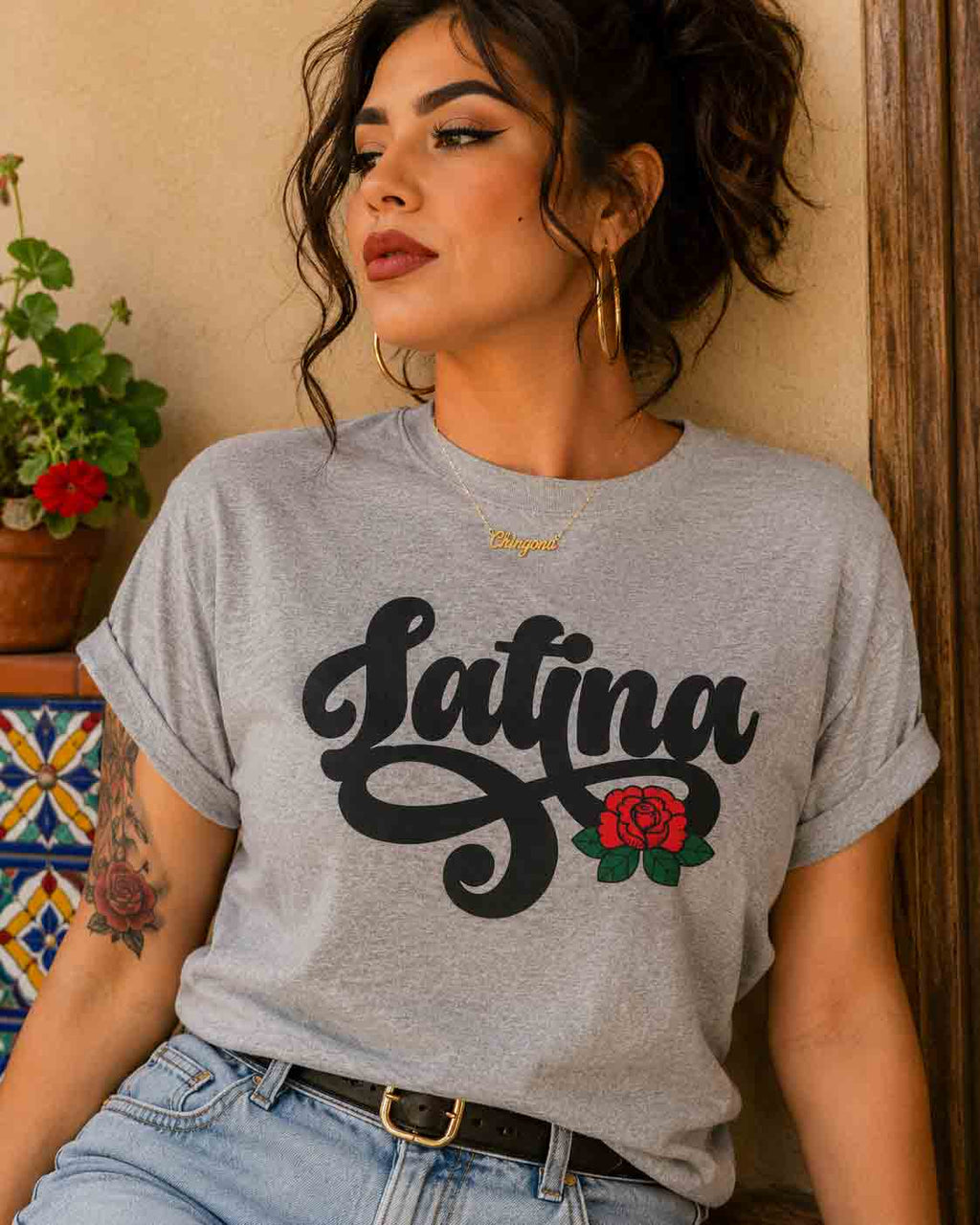 Grey t-shirt with "Latina" written in black script and a small red rose graphic on the end of the text.