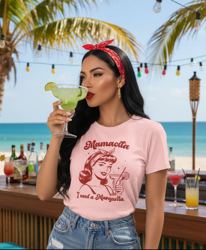 Pink t-shirt with a red vintage-style illustration of a woman holding a margarita and the text Mamacita I need a Margarita.