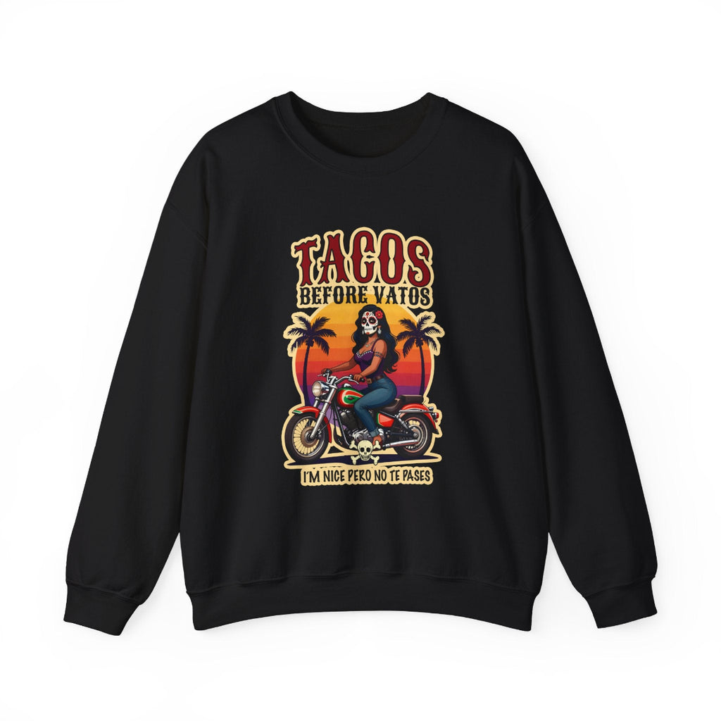 The bold “Tacos Before Vatos” lettering, featuring a vintage design of a Chicana riding a motorcycle at sunset, on a comfortable crew-neck sweatshirt.