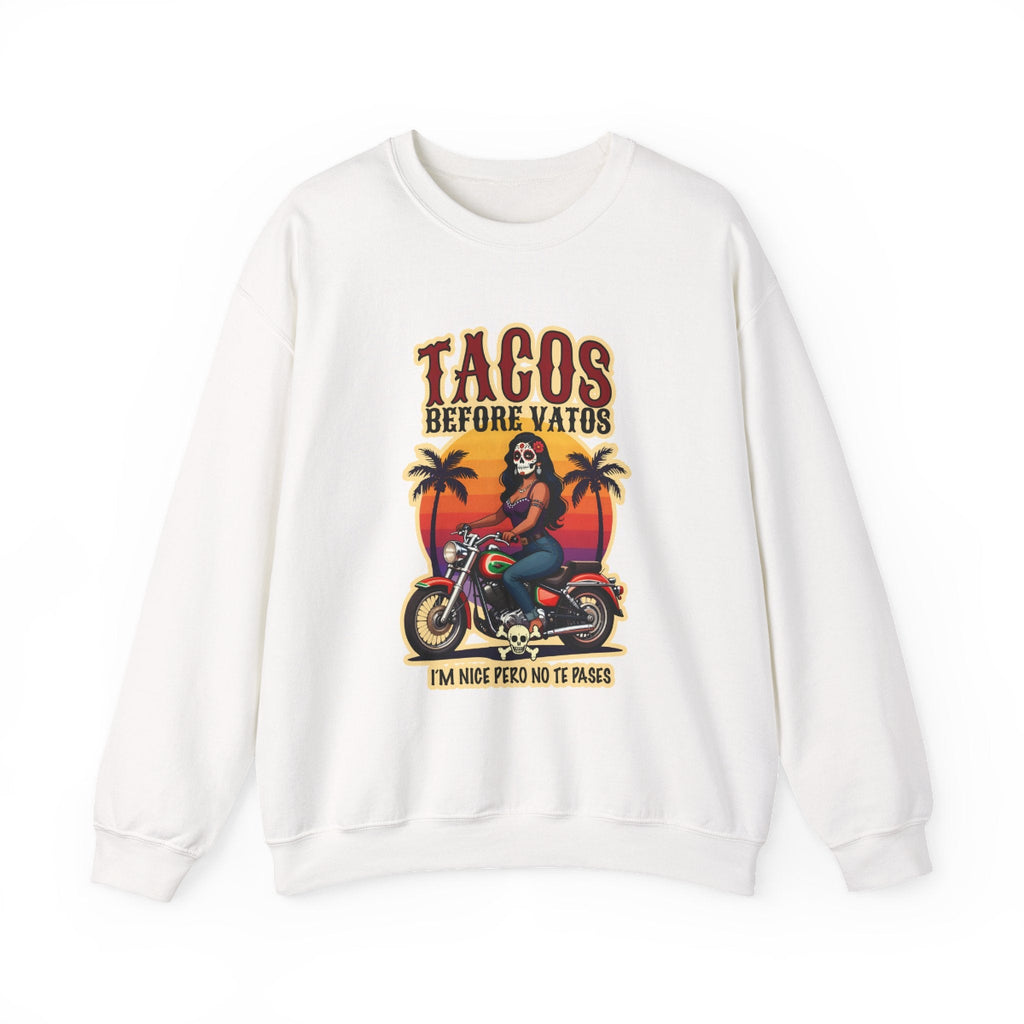 The bold “Tacos Before Vatos” lettering, featuring a vintage design of a Chicana riding a motorcycle at sunset, on a comfortable crew-neck sweatshirt.