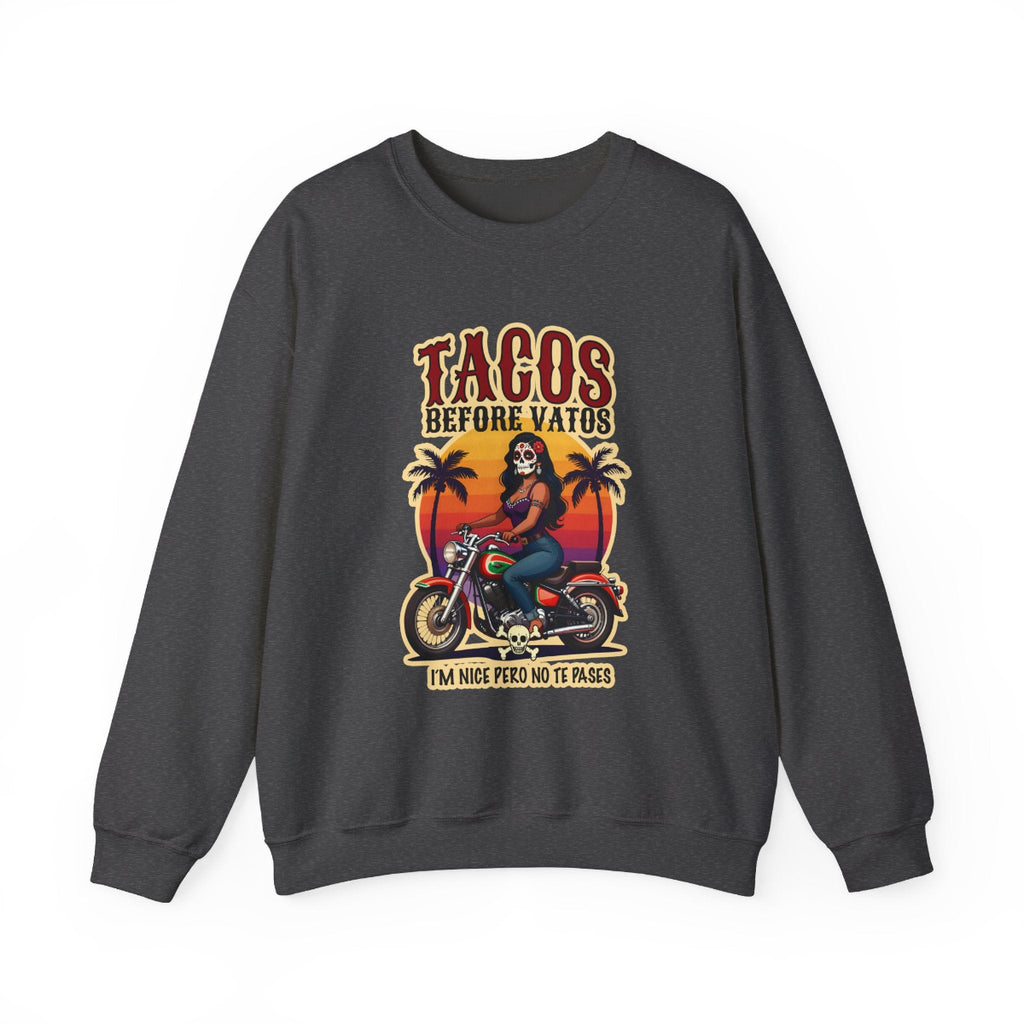 The bold “Tacos Before Vatos” lettering, featuring a vintage design of a Chicana riding a motorcycle at sunset, on a comfortable crew-neck sweatshirt.