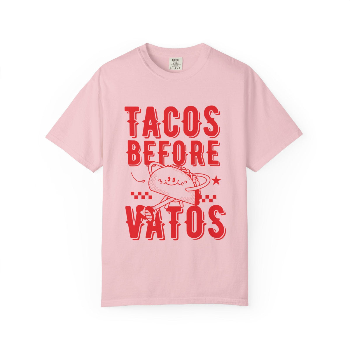 A cartoon character shaped like a taco, with the phrase “Tacos Before Vatos” printed in a bold, colorful retro 1970s font on a vintage Comfort Colors T-shirt.
