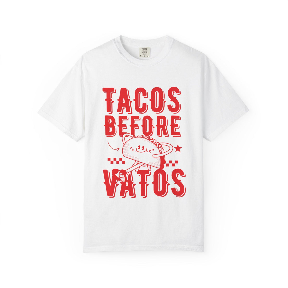 A cartoon character shaped like a taco, with the phrase “Tacos Before Vatos” printed in a bold, colorful retro 1970s font on a vintage white Comfort Colors T-shirt.