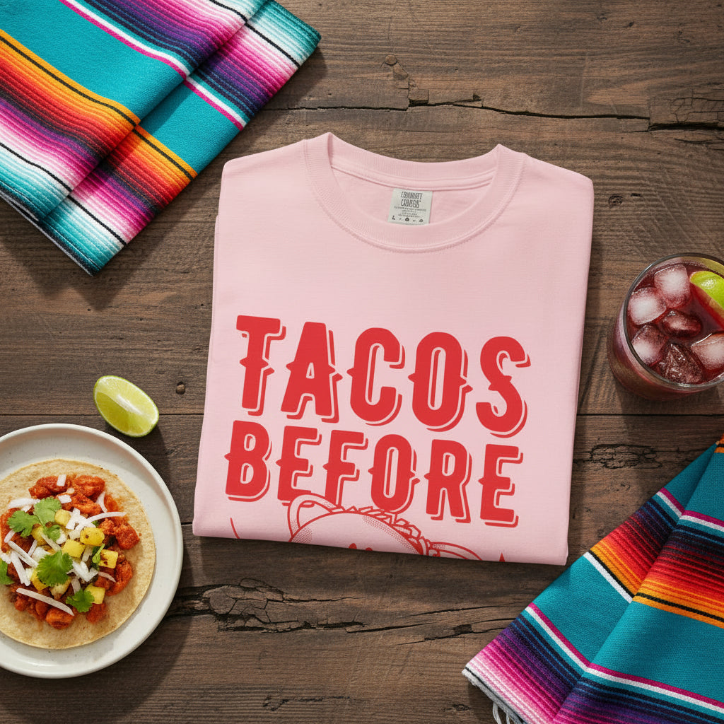 A cartoon character shaped like a taco, with the phrase “Tacos Before Vatos” printed in a bold, colorful retro 1970s font on a vintage Comfort Colors T-shirt.